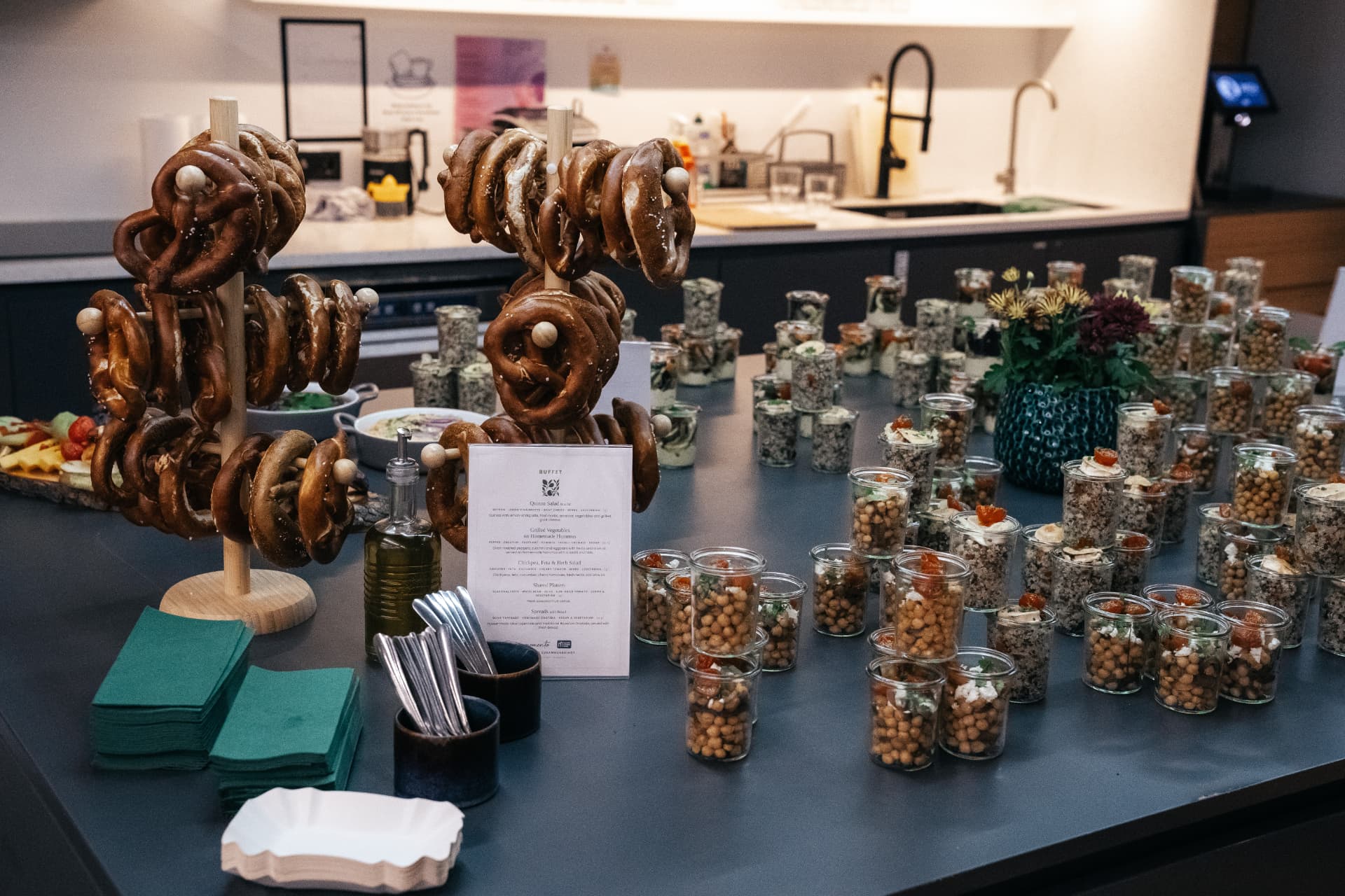 Großes Eventbuffet mit Brezen, Fingerfood im Glas, Besteck und Blumen