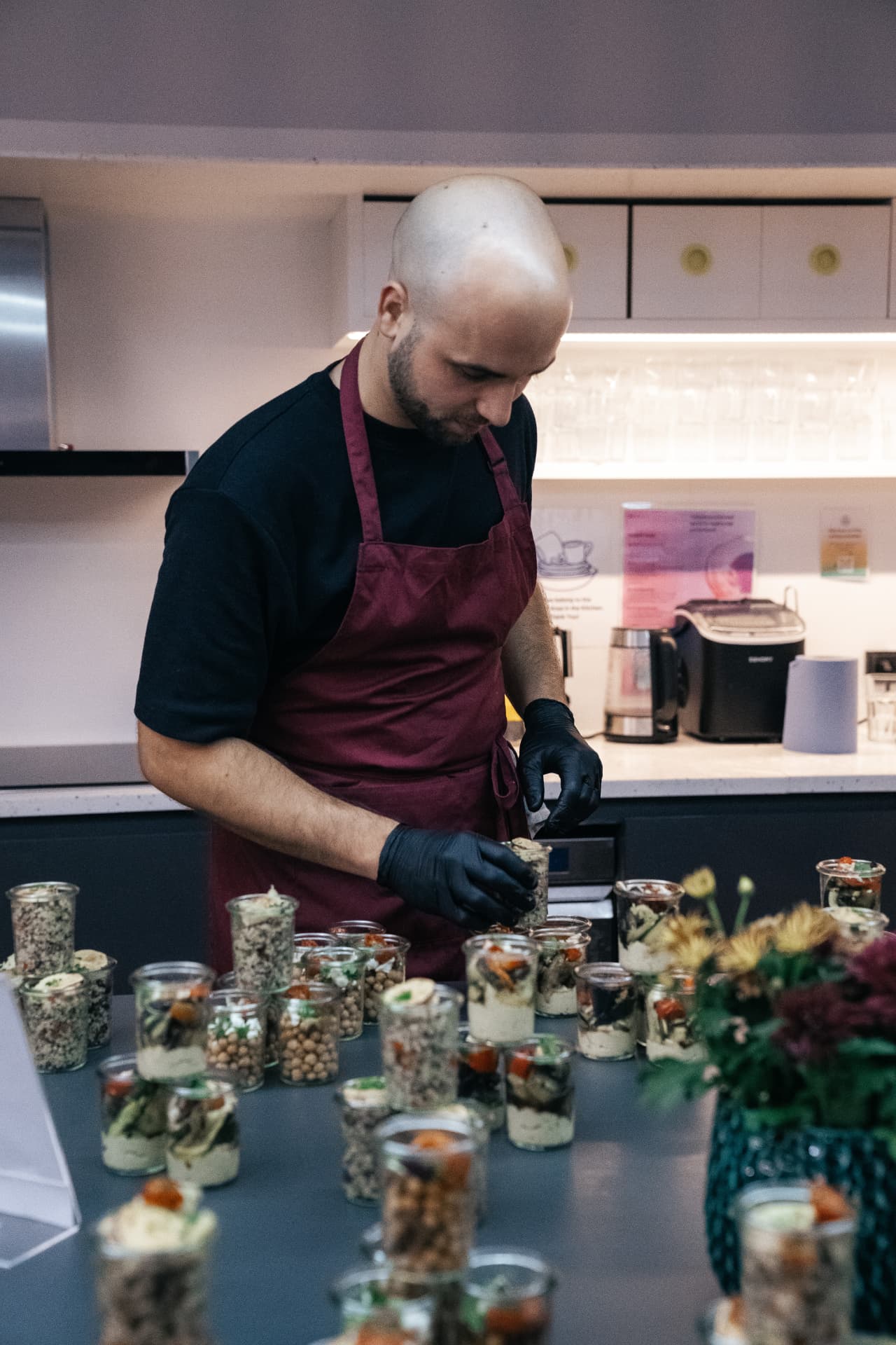 Caterer beim Anrichten vorbereiteter Speisen am Buffet